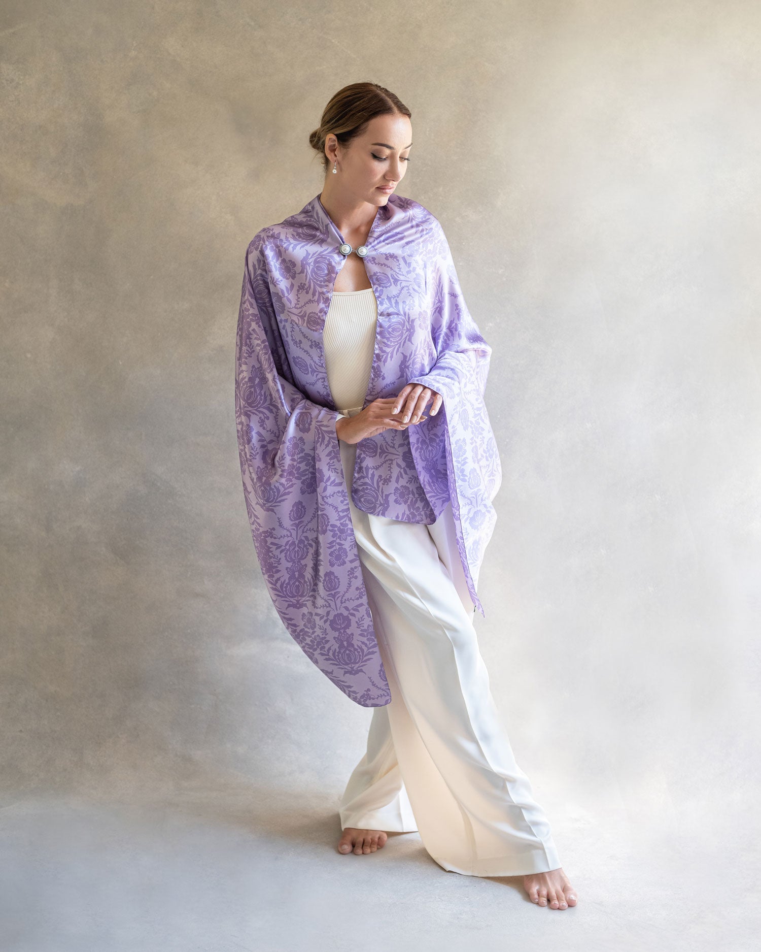 Full-body shot of a woman in a purple lavender pareo cape or shawl, posing with grace in a well-lit studio