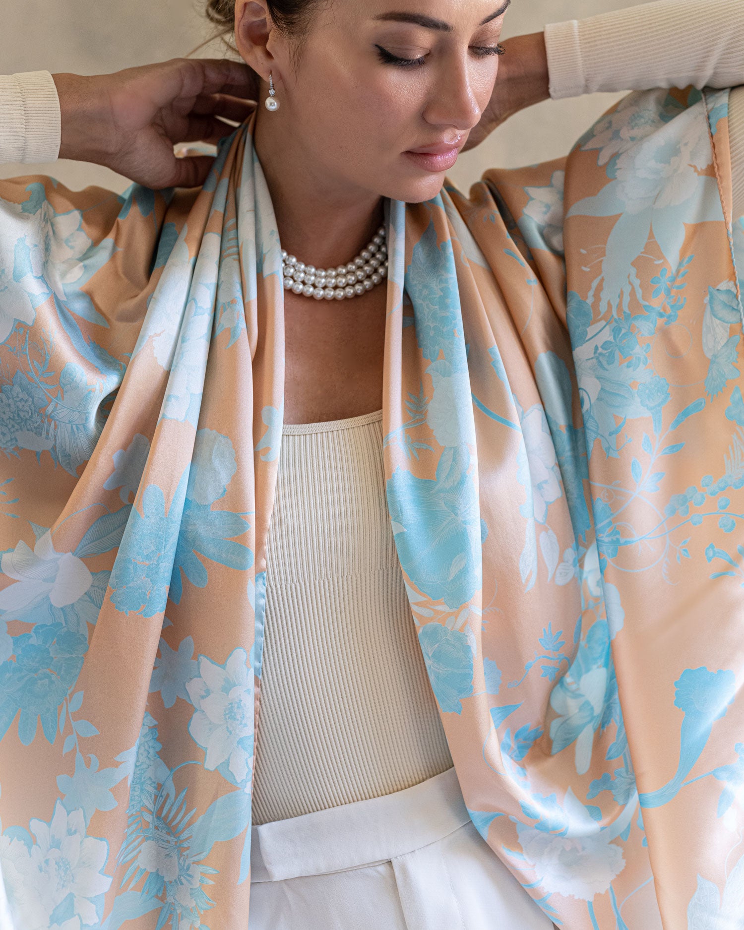 Close up elegant woman wearing a Chinoiserie orange and blue pattern pareo as a scarf 